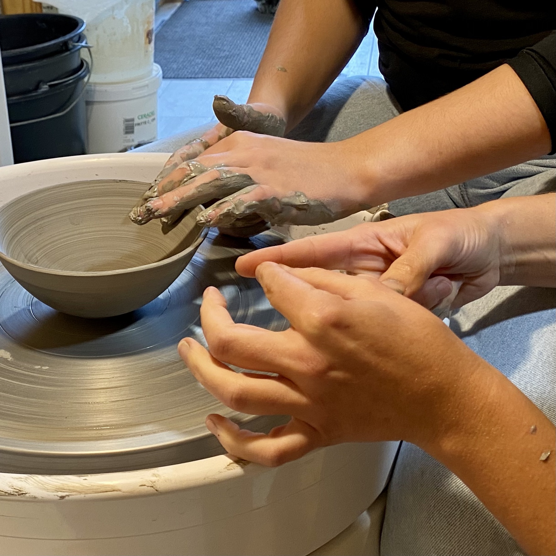 Des mains façonnent l’argile au tour de potier dans l’atelier